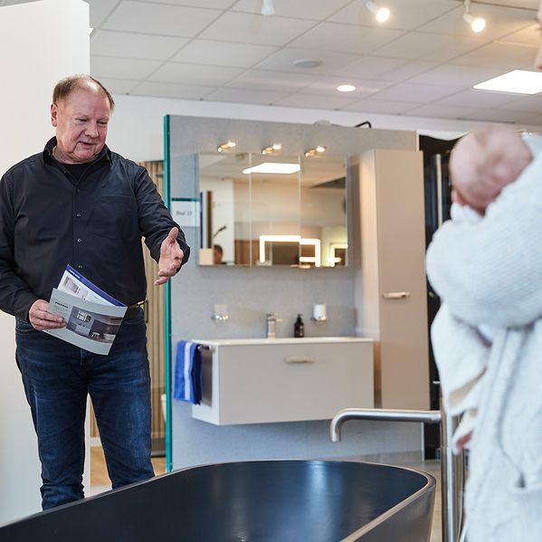 Ein Mann, der jemanden beim Badkauf berät.