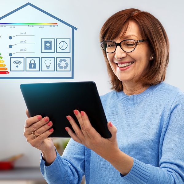 Eine ältere Frau mit einem Tablet in der Hand.