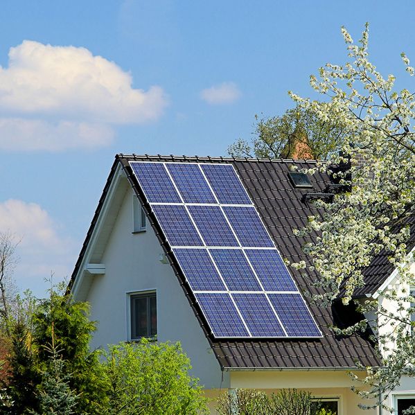 Ein Einfamilienhaus mit Solarpanelen auf dem Dach.